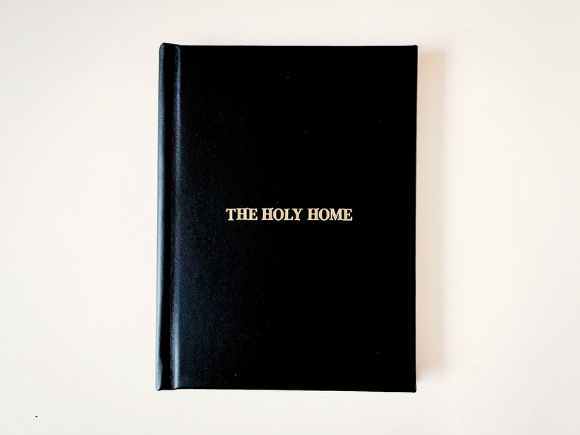 A leather book with the title The Holy Home stamped in gold