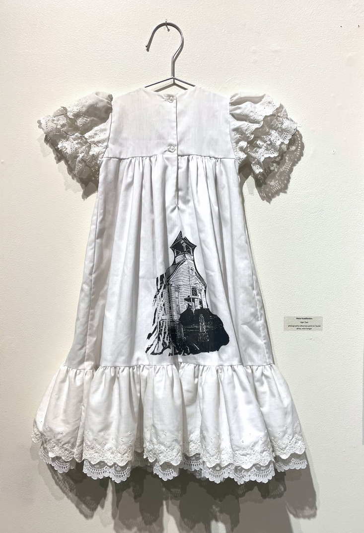 a white baby dress with a black church printed on it