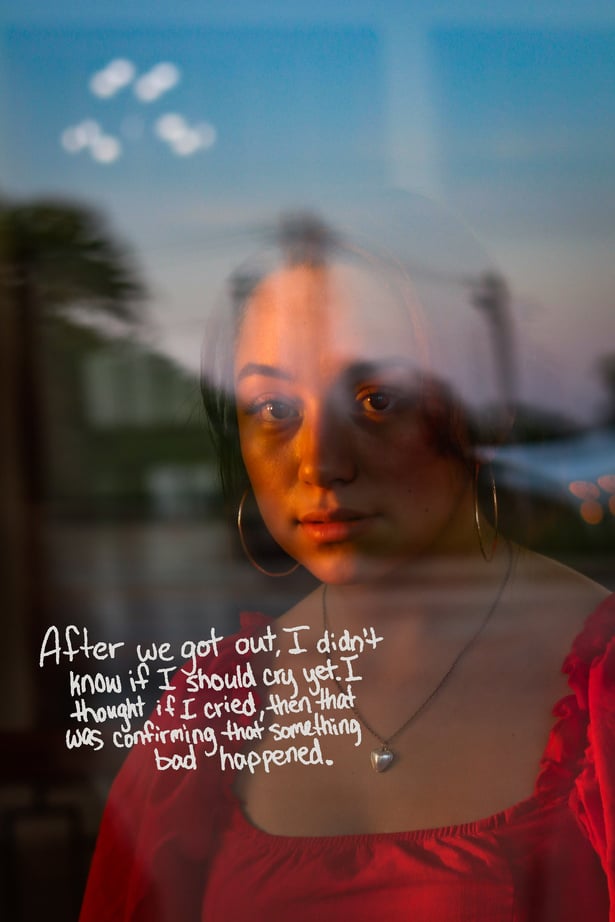 a person in a red dress reflected in a window with written text that reads "After we got out, I didn't know if I should cry yet. I thought if I cried, then that was confirming that something bad happened."