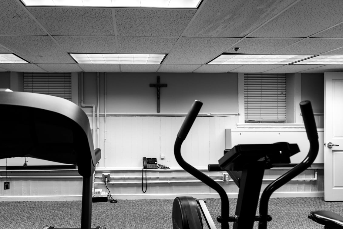 a black and white photo of a gym with a cross on the wall